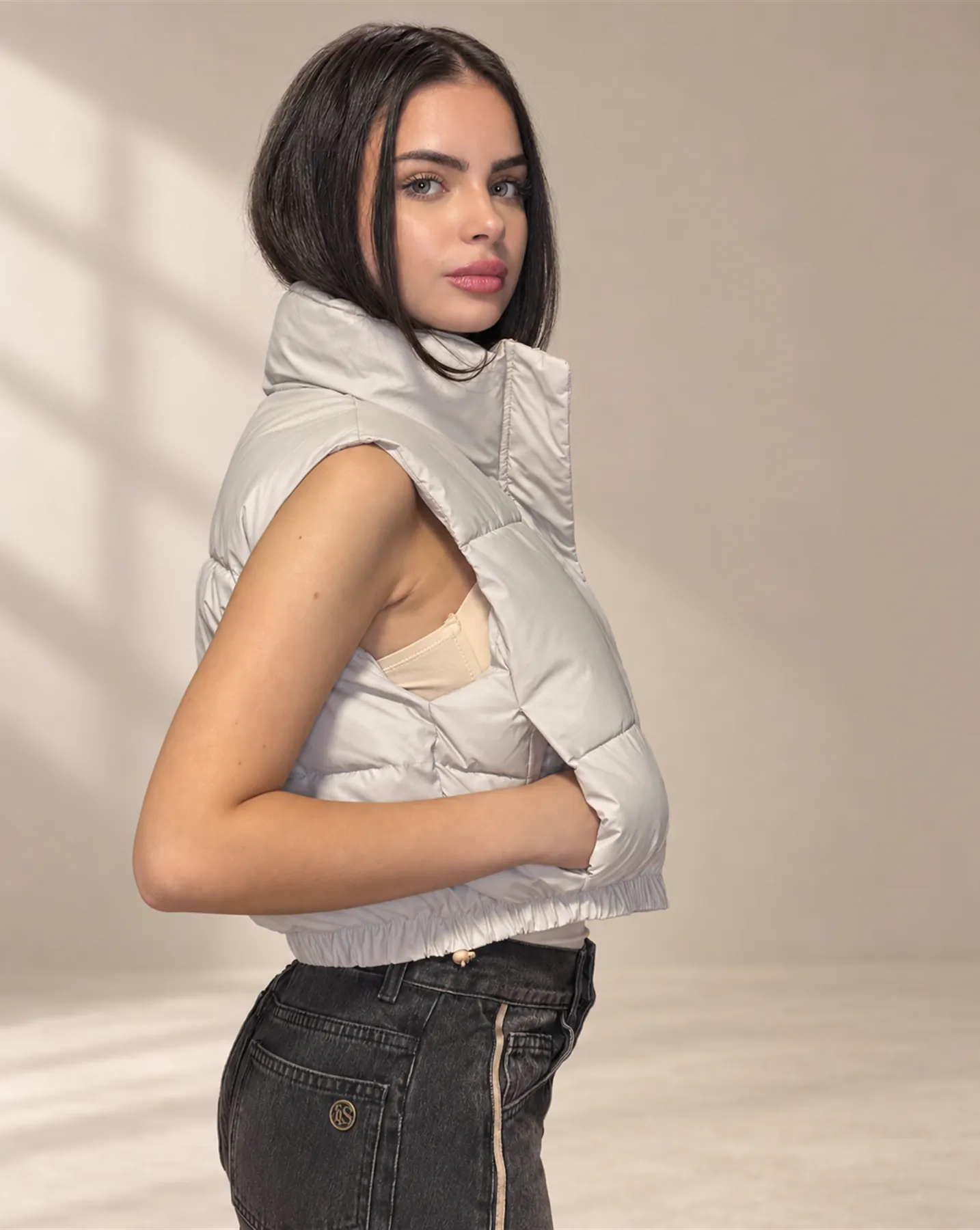 The Cropped Puffer Vest in Ecru, Over the shoulder
